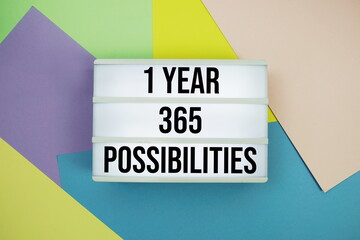 1 Year 365 Possibilities text in lightbox flat lay on colorful pastel background