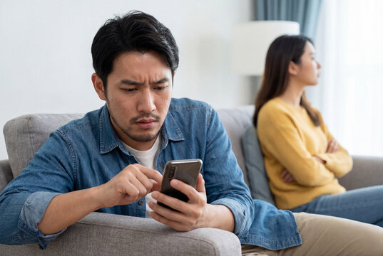 Couple conflict as jealous man reads a message on his smartphone