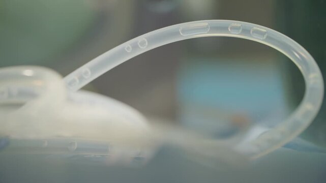 Macro shot showing transparent laboratory tubing containing droplets of fluid in a research environment.