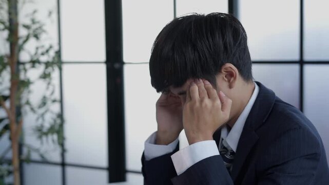 Stressed businessman holding head hard working in office