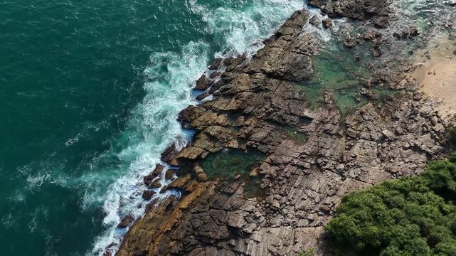 View of a rocky seashore in Sri Lanka. Blue sea waves breaking on the stones. Beautiful tropical marine landscape and geology from above.