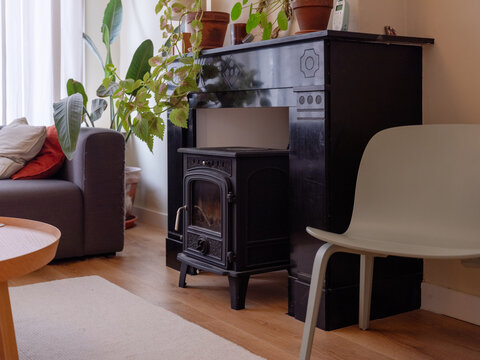 Interior of an apartment with a chimney, a wood burner and lots of plants. The chimney is original from 1916.