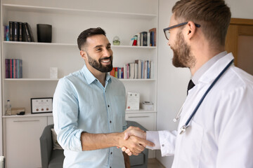 Partnership in medicine. Two smiling young men doctor and medical sales agent pharma representative...