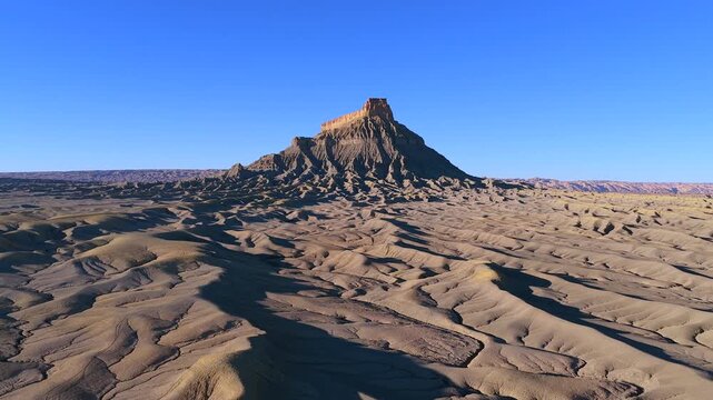 A smooth lateral drone strafe reveals the stark, moon-like ridges of Factory Butte, Utah. This 4K landscape offers a perfect universal backdrop for alien worlds or extraterrestrial planets.
