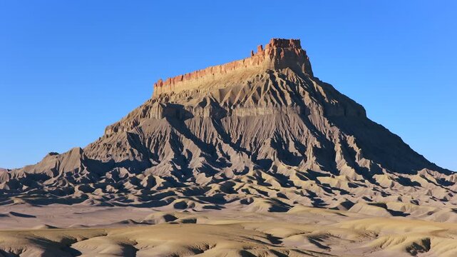 This 4K drone shot captures the sharp textures and intricate erosion of Factory Butte&rsquo;s summit. The grey Mancos Shale provides a stark, alien-world aesthetic perfect for universal sci-fi needs.