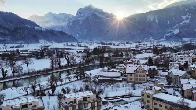 Winter aerial view of snowy Wessen town near alpine lake.
Romantic Swiss scenery with peaceful winter mood. Drone close shot