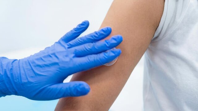 Wearable biosensor adhesive patch upper arm for continuous health monitoring and gentle sensor contact with medical glove during clinical care sensor