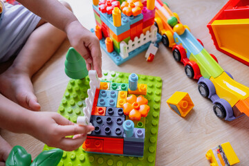 Child playing with colorful plastic building blocks and toy. The scene highlights creativity, imagination and early childhood development through play.