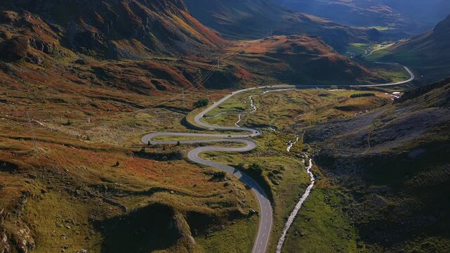 Aerial view showing Julier Pass mountain landscape with a captivating winding road and stream