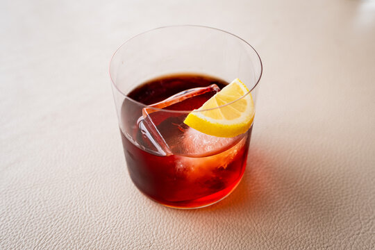 Classic Negroni Cocktail with Ice Cube and Lemon Slice in Glass