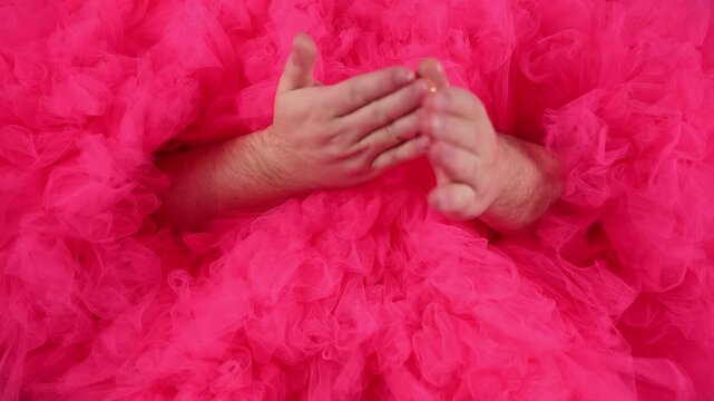Defocused horizontal 4K video close up. Man in pink magenta tulle fur coat male hands with gloss, gold glitter sparkle, cream. Concept of dance, birthday, holiday, lgbt, diverse beauty, disco