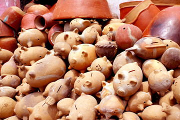 Variety of clay crafts made in Nicaragua, pig-shaped piggy banks, pots and flower pots.