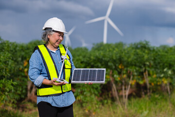 woman wearing a yellow vest holding a solar panel