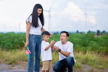 family of three, a man and two children, are standing in a field
