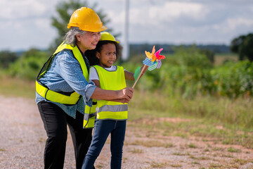 woman and a child are standing on a road, with the woman wearing a yellow vest