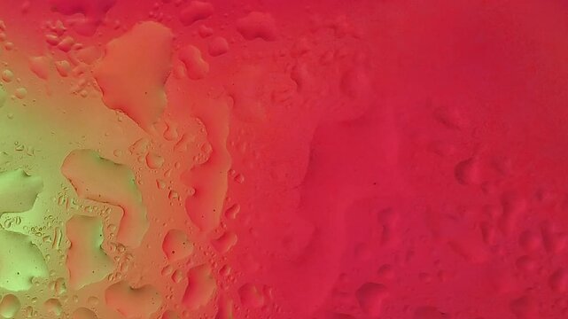 Close-up of a textured surface with a gradient of red and green colors, transitioning from light to dark with a bumpy, rough pattern.