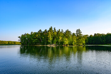 Obraz premium Tranquil summer lakeside island reflection