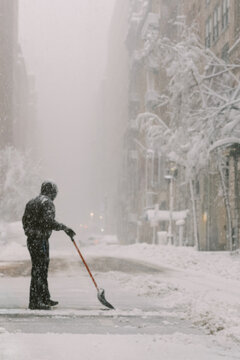 Person shoveling snow during NYC blizzard