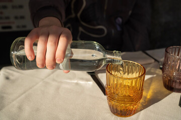 nalewanie wody do szklanki przy stoliku w restauracji w słoneczny upalny dzień © siwyk