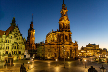 Obraz premium Evening view of Dresden Cathedral and historic buildings on Theaterplatz with illuminated Baroque architecture in Saxony's old town.