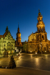 Obraz premium Evening view of Dresden Cathedral and historic buildings on Theaterplatz with illuminated Baroque architecture in Saxony's old town.