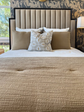 Upholstered Bed with Tan Bedding Accents