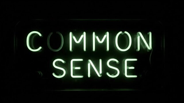 Neon green illuminated sign spelling out the words common sense in a dark environment for a concept