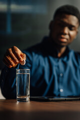 African american man dropping effervescent pill in water