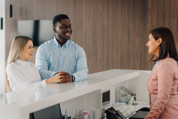 Multiethnic couple checking in at hotel reception desk
