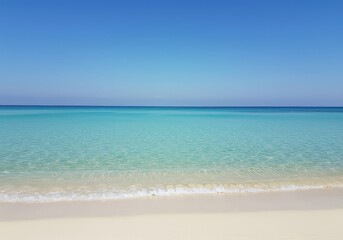 Fototapeta premium Clear turquoise ocean water washing onto a pristine, warm, tropical sandy beach under a bright blue sky. Idyllic summertime escape ,white ,travel ,getaway