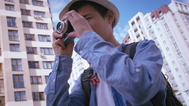 Urban Exploration Journey: Young Boy with a Camera Seeking Perfect City Shots