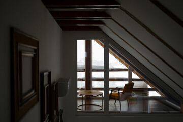 Cozy lobby of a modern mountain lodge with a view. Snow is covering the windows.