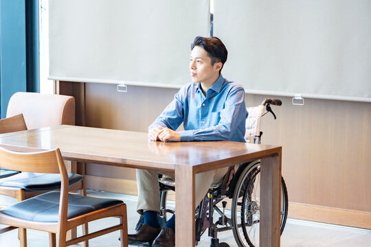 接客をされる車椅子の男性がダイニングテーブルに座っている、バリアフリー・多様性をテーマにしたシーンですね。