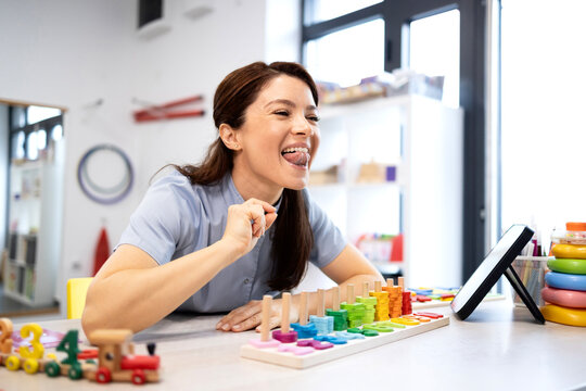 Speech language pathologist demonstrating tongue exercises during a therapy session, helping with articulation, speech development, and oral motor skills in a clinic setting