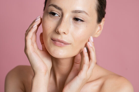 Portrait Woman with clear glowing skin on soft pink background