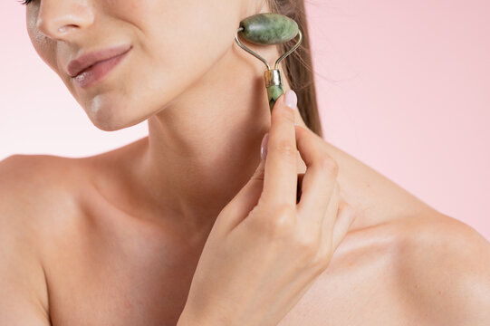 Portrait Woman with clear glowing skin on soft pink background