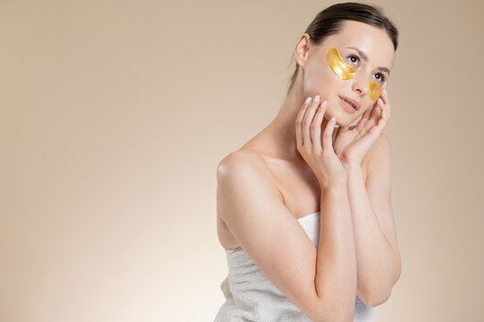 Brunette Woman skincare routine at beige studio background