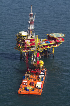 Netherlands, Netherlands - 13 February 2026: Aerial view of a vibrant offshore oil rig platform with its helipad, nestled in the deep blue sea.