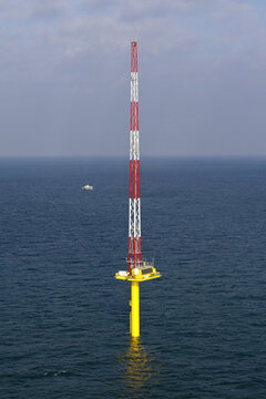 Netherlands, Netherlands - 13 February 2026: Aerial view of a striking, red and white striped structure rising boldly from the deep blue sea, a testament to engineering marvels.