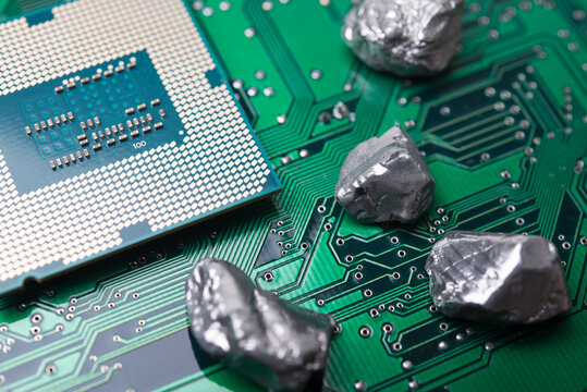 Mineral rare earth element and CPU on green electronic circuit board background. US vs China chip war, tech war, semiconductor industry concept. China curbs on exports of rare earth element to US.
