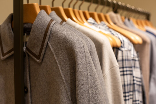 Coat on hanger in business casual store. Business attire for inclement weather. Business attire in premium clothing store. Expensive items on a hanger for luxury shopping spree
