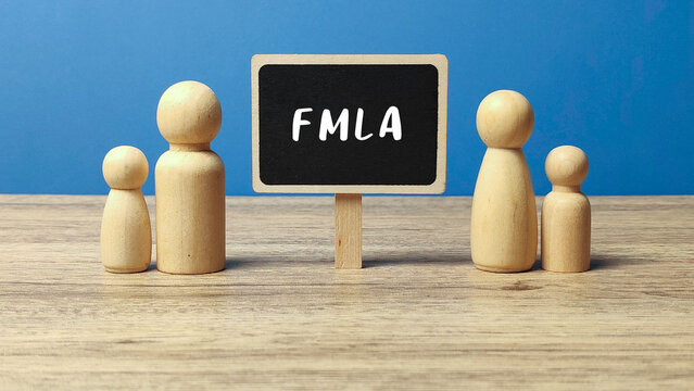 Family and Medical Leave Act Concept with Wooden People Figures and Blackboard