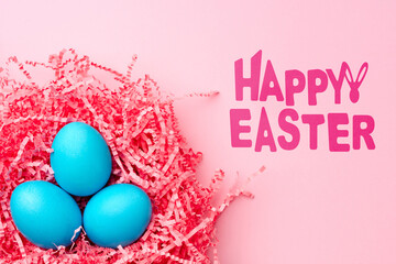 Fototapeta premium Colorful blue eggs in pink straw celebrate Easter holiday festivities and joy