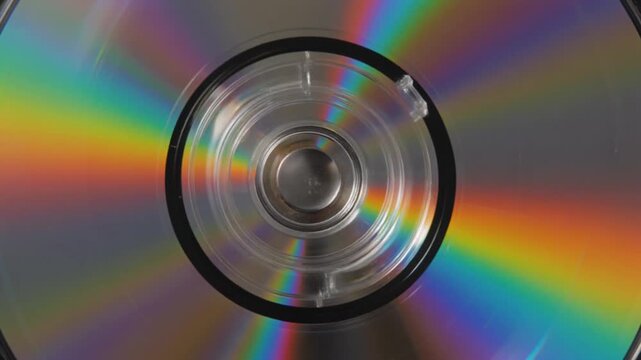 "A close-up of a compact disc reflecting rainbow colors from light diffraction, symbolizing data storage, technology, and the interplay of science, optics, and digital innovation in modern design."