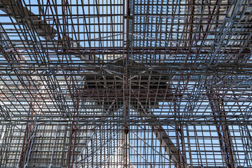 Uprisen angle photo shot of the huge steel roof frame structure detail under construction at the work site.