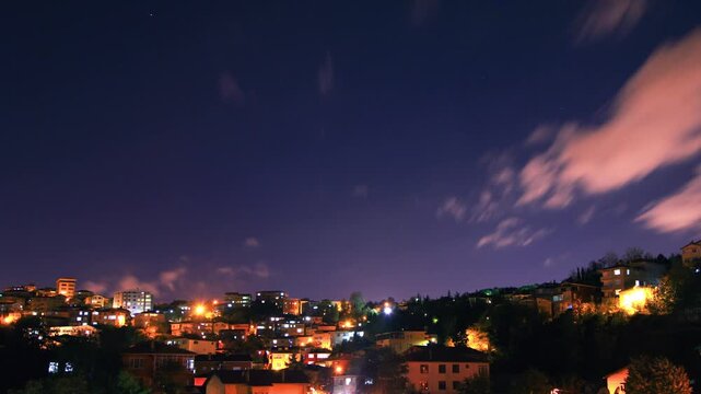 Cinematic 4K night timelapse of Istanbul city lights and moving clouds, glowing windows of residential houses and street illumination, urban lifestyle at night.