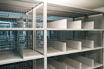 Obraz premium White shelves are lined up all over the area in a warehouse with a green floor. It also has an excellent security system.