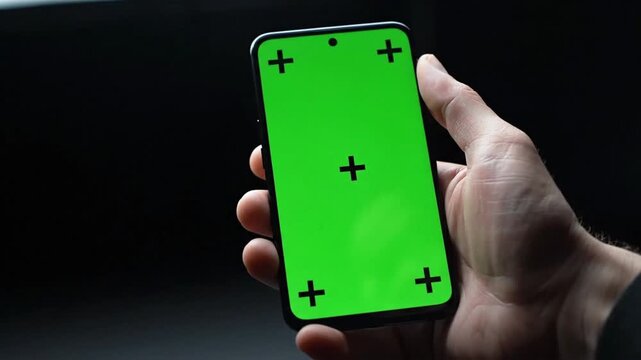 Using a smartphone with a green screen for app testing and demonstrations in a dark room