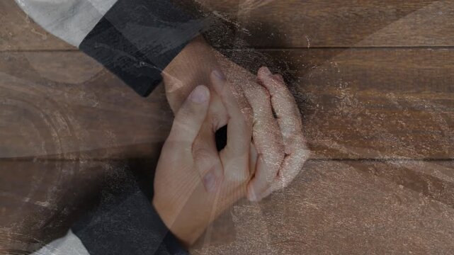Clasped hands making thumb motions after nudge, adjusting grip over wood plank with scratch overlay