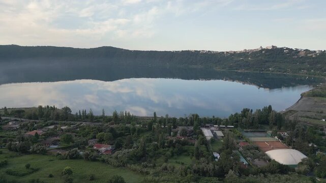 Ascending drone video captures a scenic view of volcanic lake located in Alban hills southeast from Rome, Lazio, Italy.